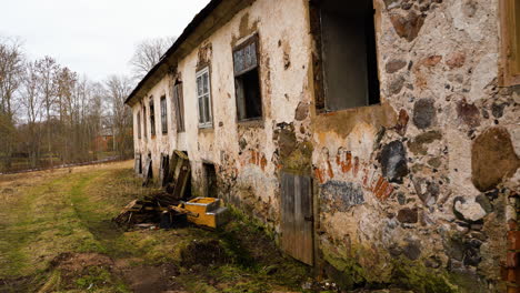 Antiguo-Edificio-De-Piedra-Abandonado-De-La-época-De-La-Unión-Soviética-Con-Ventanas-Rotas,-Muñeca-En