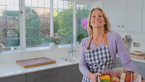 portrait of woman unpacking online meal food recipe kit delivered to home - shot in slow motion