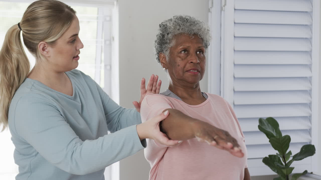 Caucasian female physiotherapist with senior woman exercising, copy space, slow motion