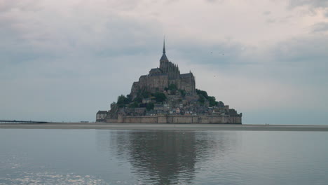 rocky island with mont saint michel and monastery in normandy, france