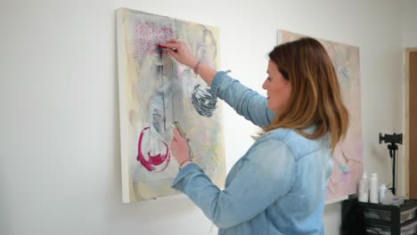 artista femenina dibujando una figura en un lienzo, de pie en un estudio casero