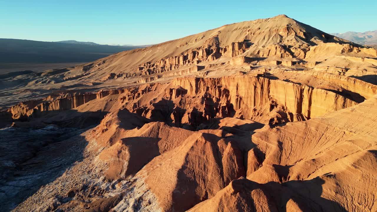 Cinematic aerial view highlighting the dramatic contrast between fiery orange cliffs and pale flats at dusk