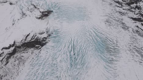 aerial landscape view over ice cracks and formations in virkisjokull glacier covered in snow, iceland