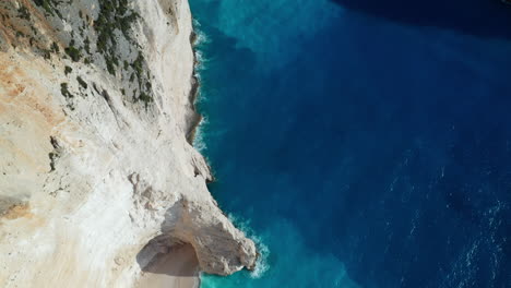 Filmische-Drohnenaufnahmen-Zeigen-Den-Schiffswrackstrand-Am-Navagio-Strand,-Kristallklares-Wasser