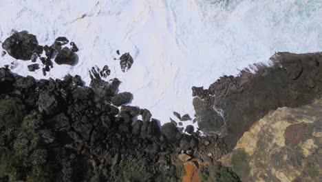 costa rocosa con olas espumosas, vista aérea de arriba hacia abajo