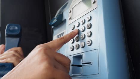 person using a public payphone