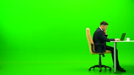 The businessman working with a laptop and doing exercise on the green background