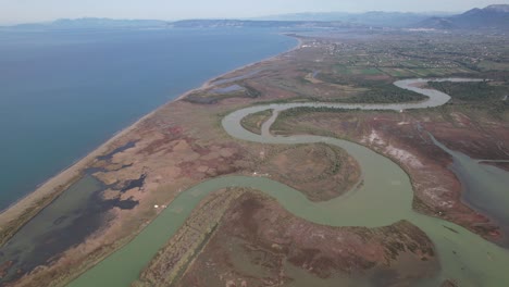 River-flows-along-a-shallow-lagoon-near-the-coast-of-Albania,-natural-habitat-for-fish-and-birds