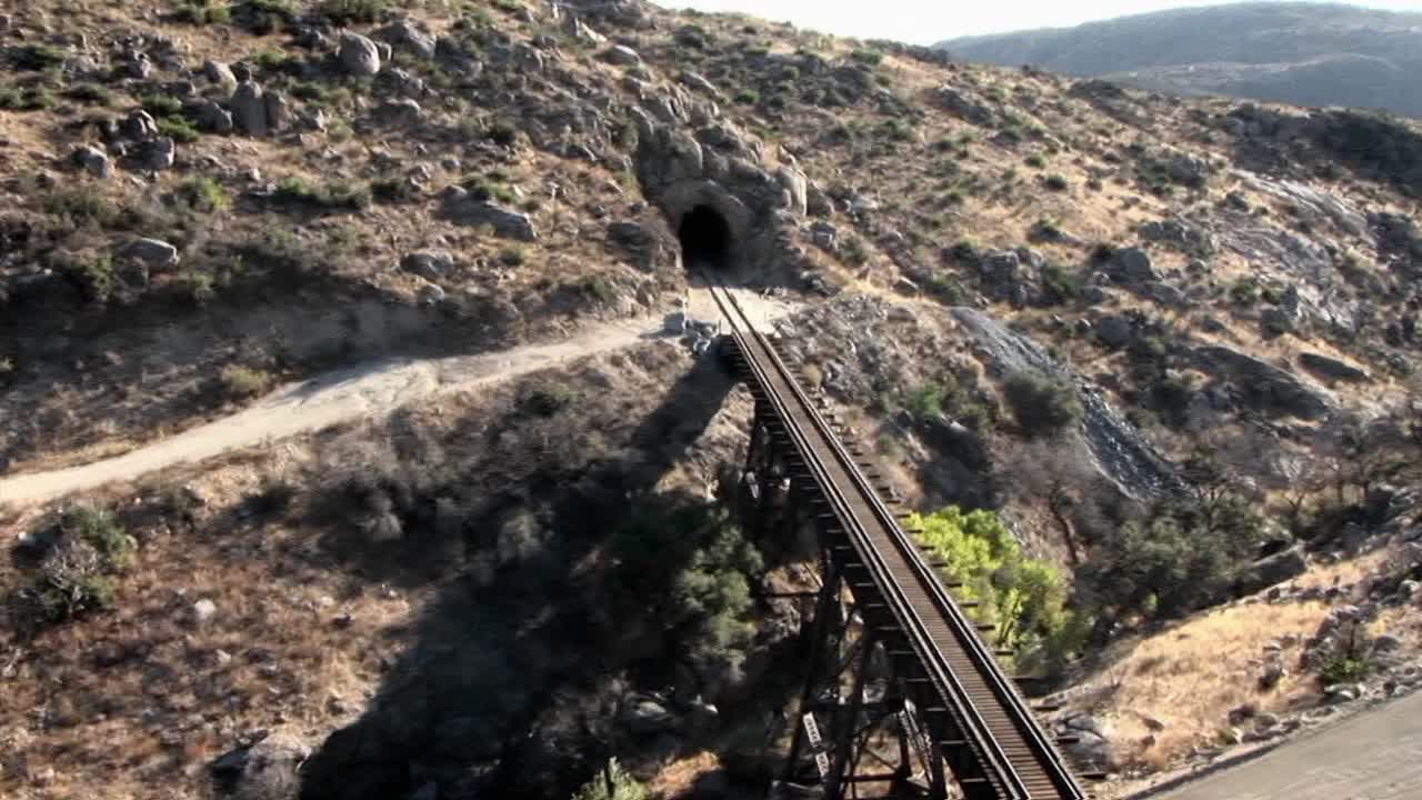 el humo se eleva como una indicación de que un tren está cruzando un puente y se dirige a un túnel