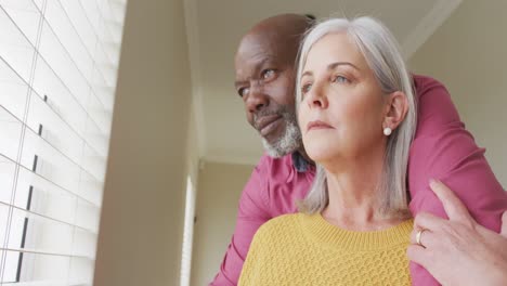 Happy-senior-diverse-couple-looking-through-window