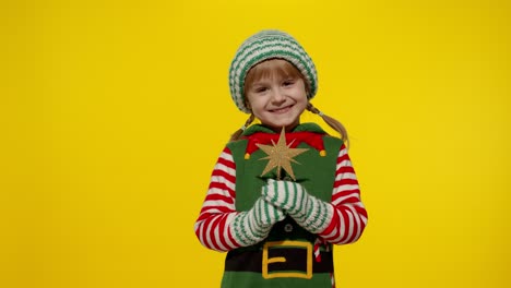 Kid-girl-in-Christmas-elf-Santa-helper-costume-holding-star-toy-and-making-a-wish.-New-Year-holiday