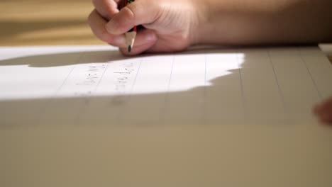 close up, young childs hand writing with a pencil on paper