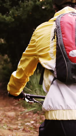 motociclista de montaña masculino montando en el bosque