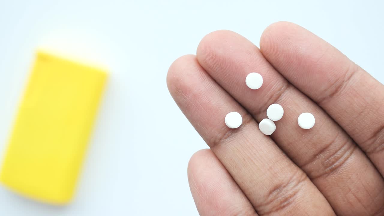 색 둥근 알약을 들고 있는 손