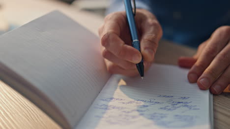 el autor de primer plano escribe un cuaderno en la oficina. hombre creativo notando en el papel