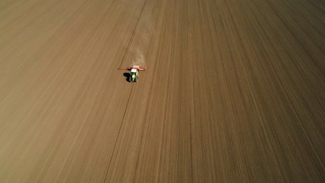 vista aérea de una siembra de tractor verde, sembrando cultivos agrícolas en el campo con polvo detrás