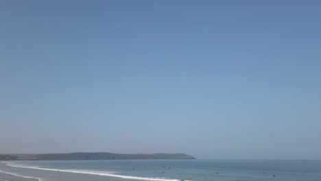 surfers in the waves on a summer’s day fading out to blue sky