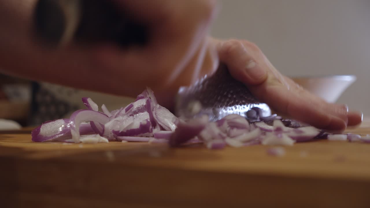 Chopping onion with sharp knife on a cut board