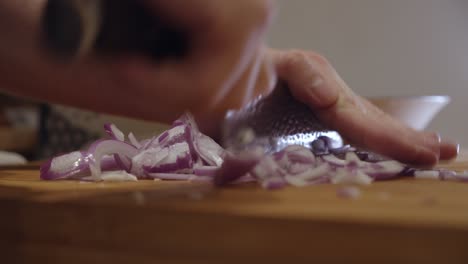 chopping onion with sharp knife on a cut board