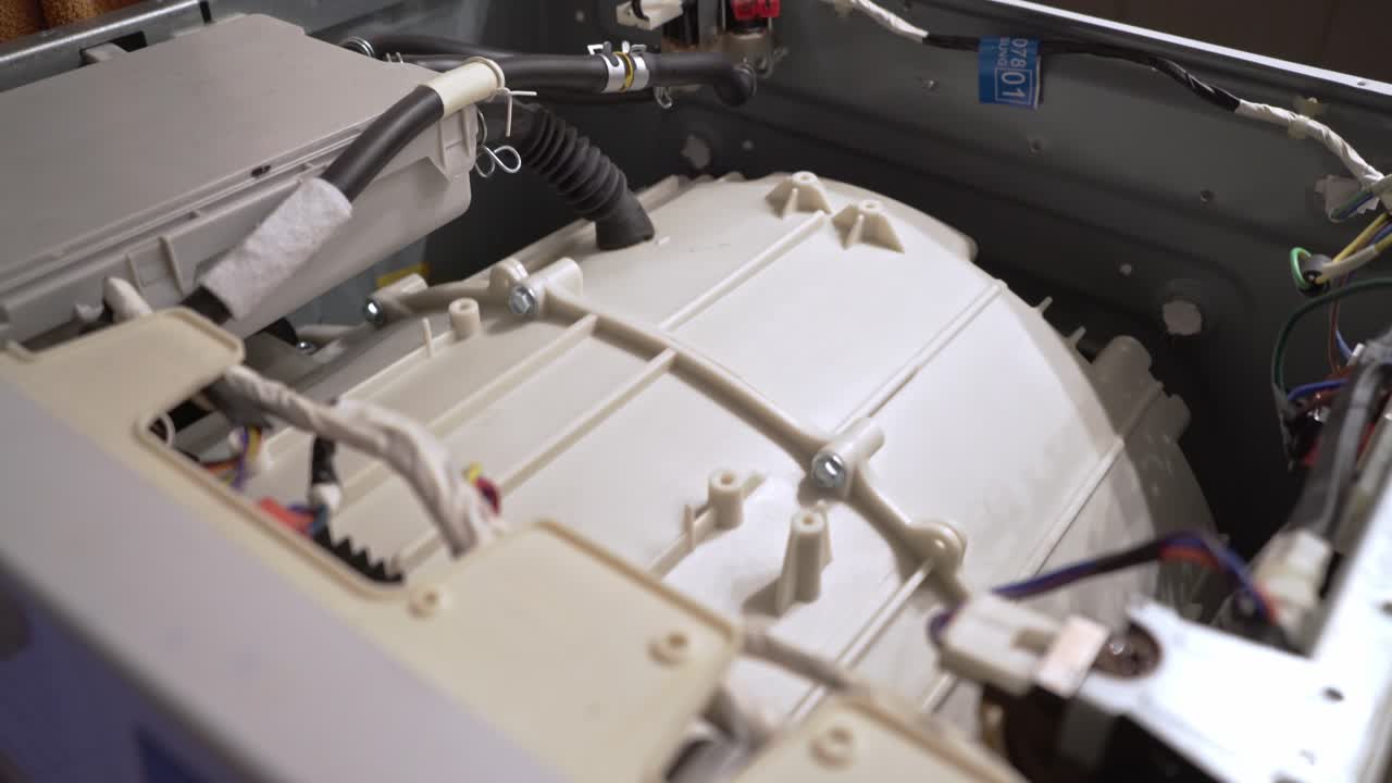Close up at the interior mechanism of washing machine while it's working 4k, side view