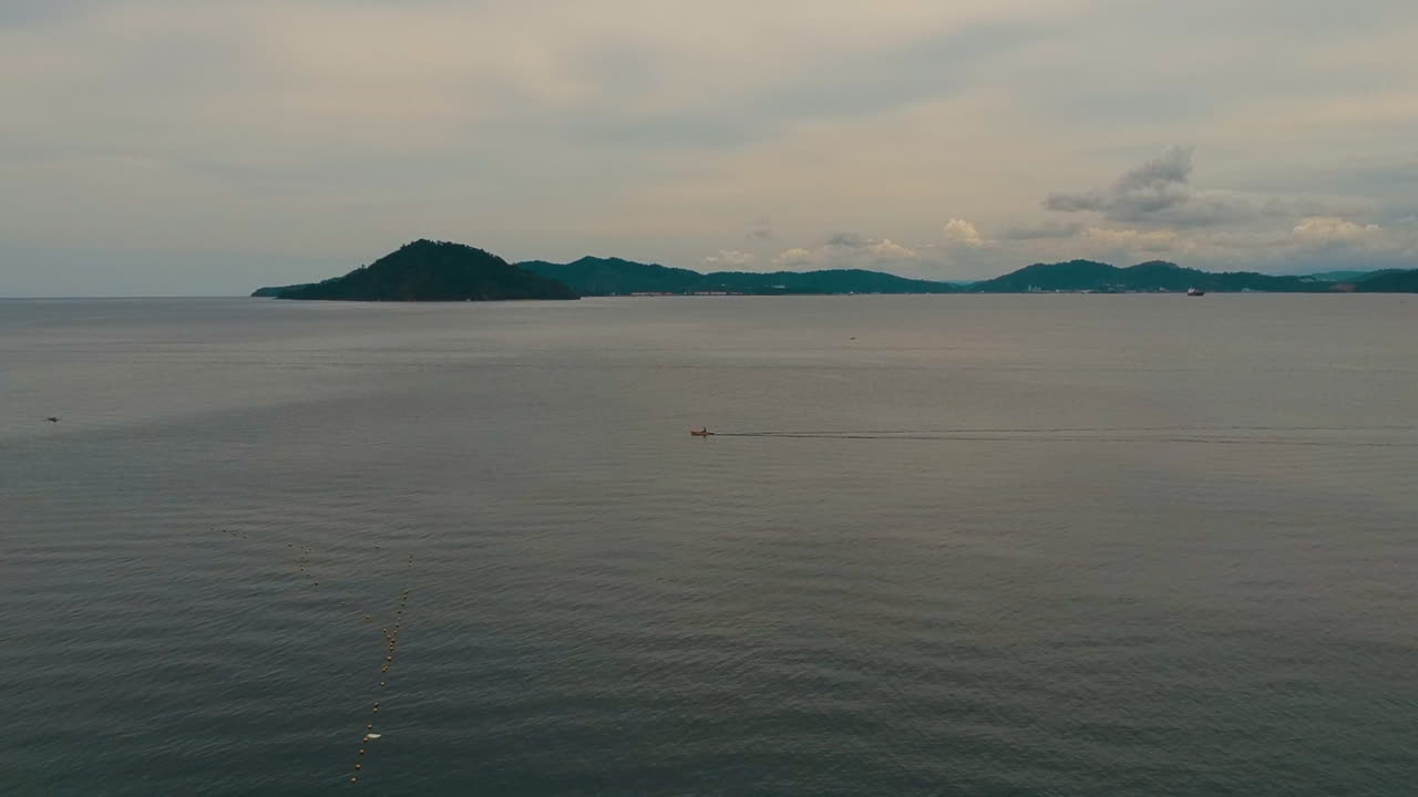 드론은 말레이시아 보르네오 섬 사이에서 바다를 건너는 쾌속정을 따라갑니다.