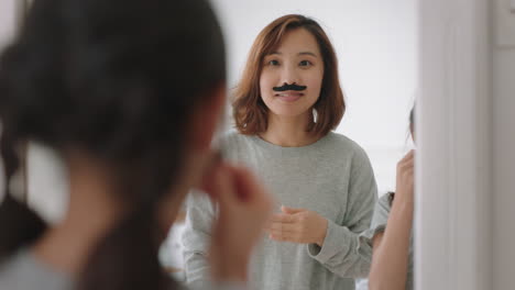 asian-mother-and-daughter-playing-dress-up-game-at-home-wearing-moustaches-little-girl-having-fun-with-mom-enjoying-playful-day-with-child-together-on-weekend-happy-family-4k-footage