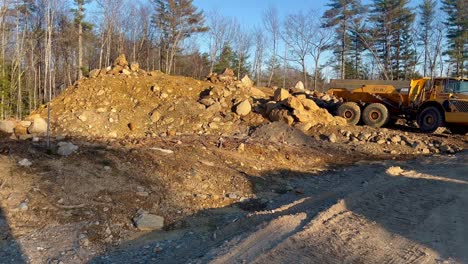 larger commercial dump truck, pile of dirt and stones for foundation materials