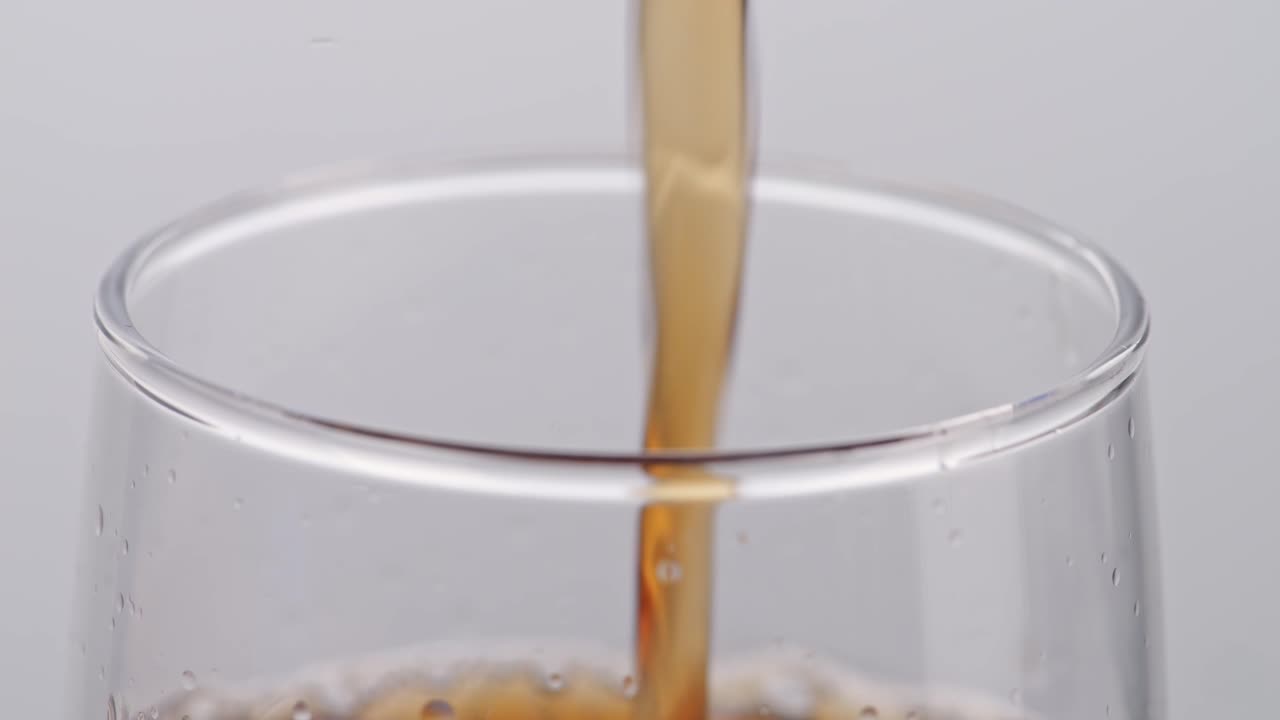 색 배경 에 있는 유리잔 에 여 있는 신선 한 콜라 의 근접