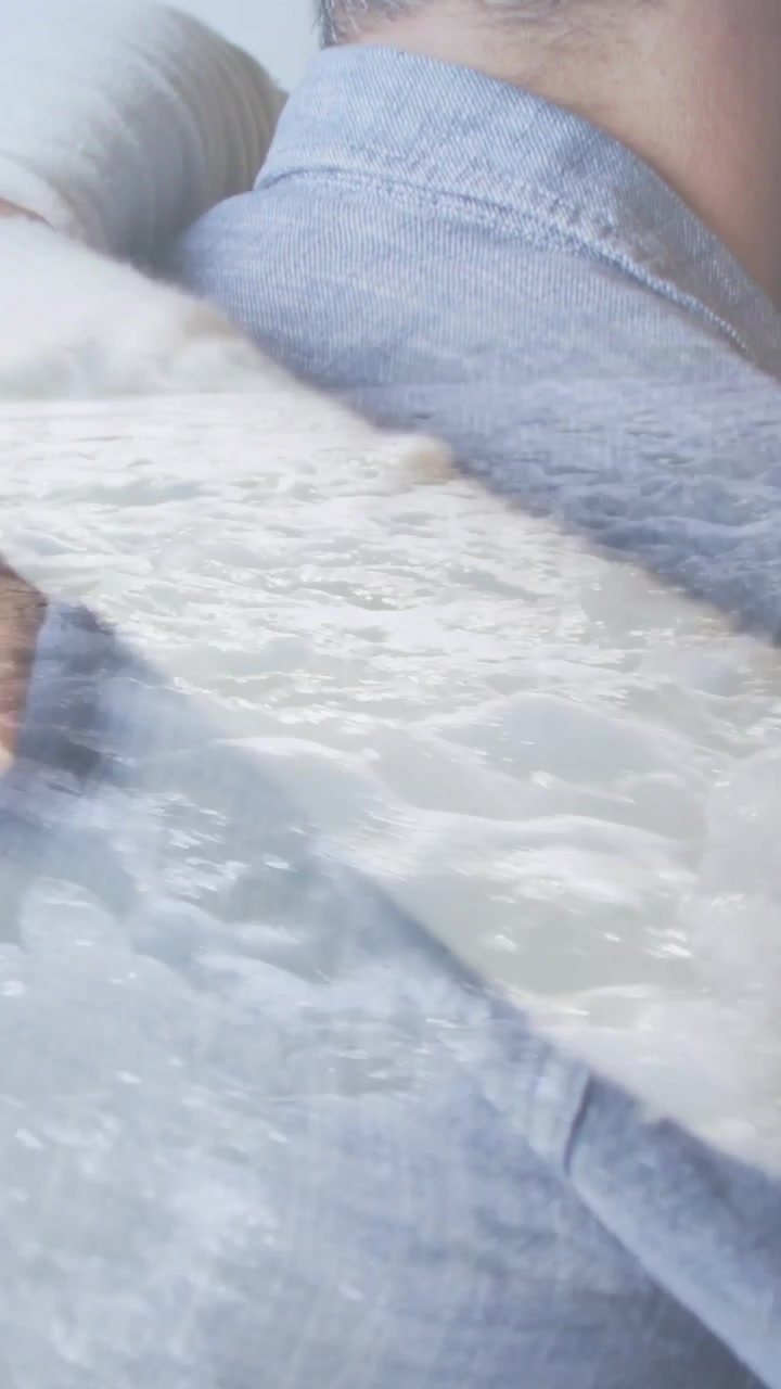 Video verticale: Donna che si avvicina e abbraccia un uomo in cucina prendendosi cura di lui con una sovrapposizione d'acqua per la salute.