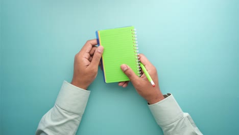 person taking notes with spiral notebook