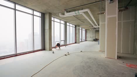 push in shot of an empty penthouse under construction, showcasing the spacious interior and potential design