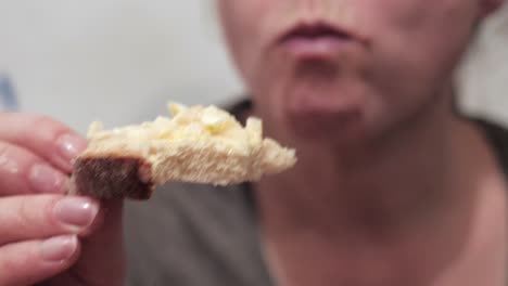 mujer con uñas sucias está comiendo un sándwich con mantequilla y ajo