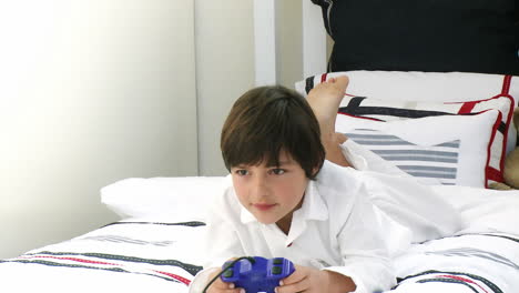 boy on his bed playing video games