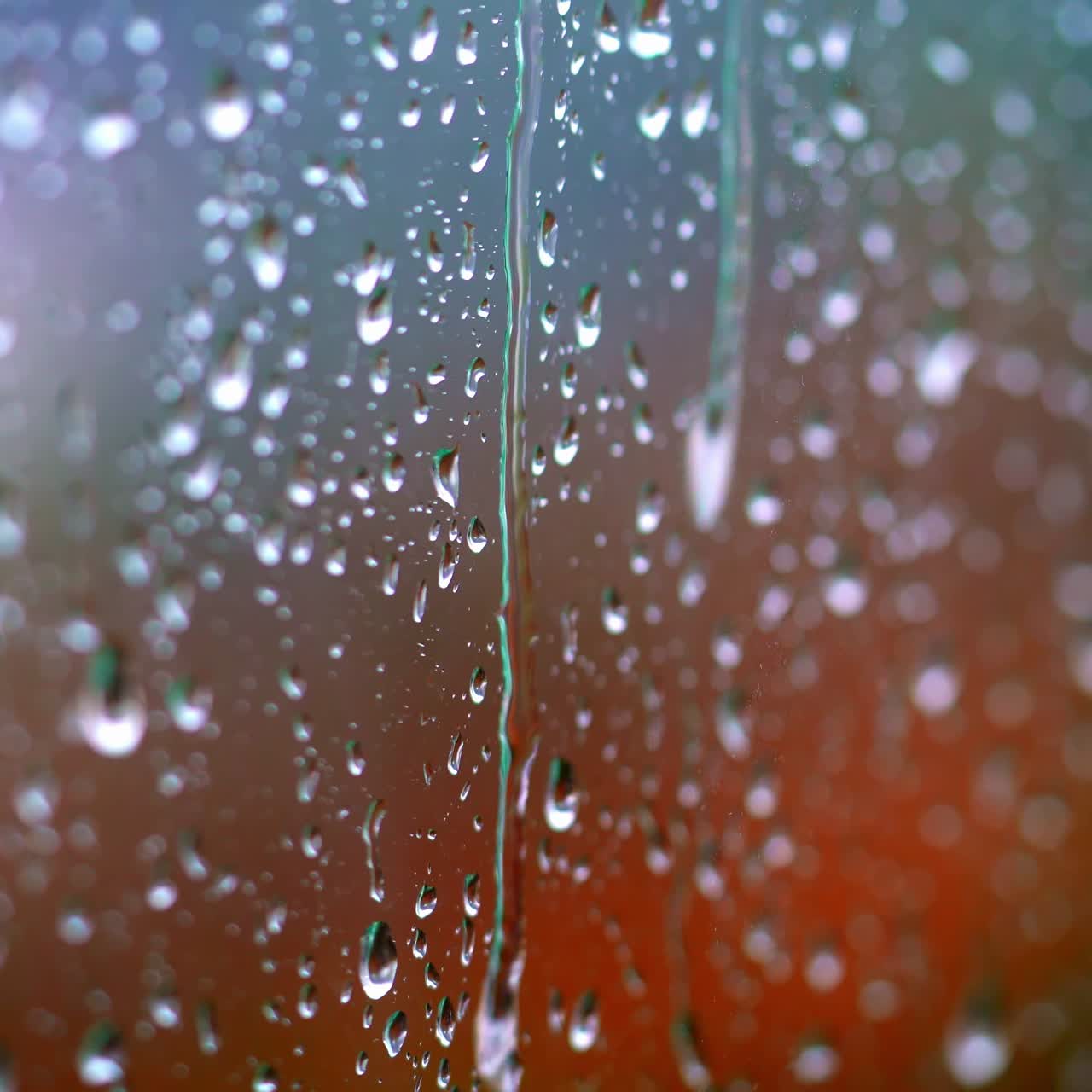 Rainy days. Heavy rain falling on window surface. Rain water drops falling down on the window glass. White water drops on glass