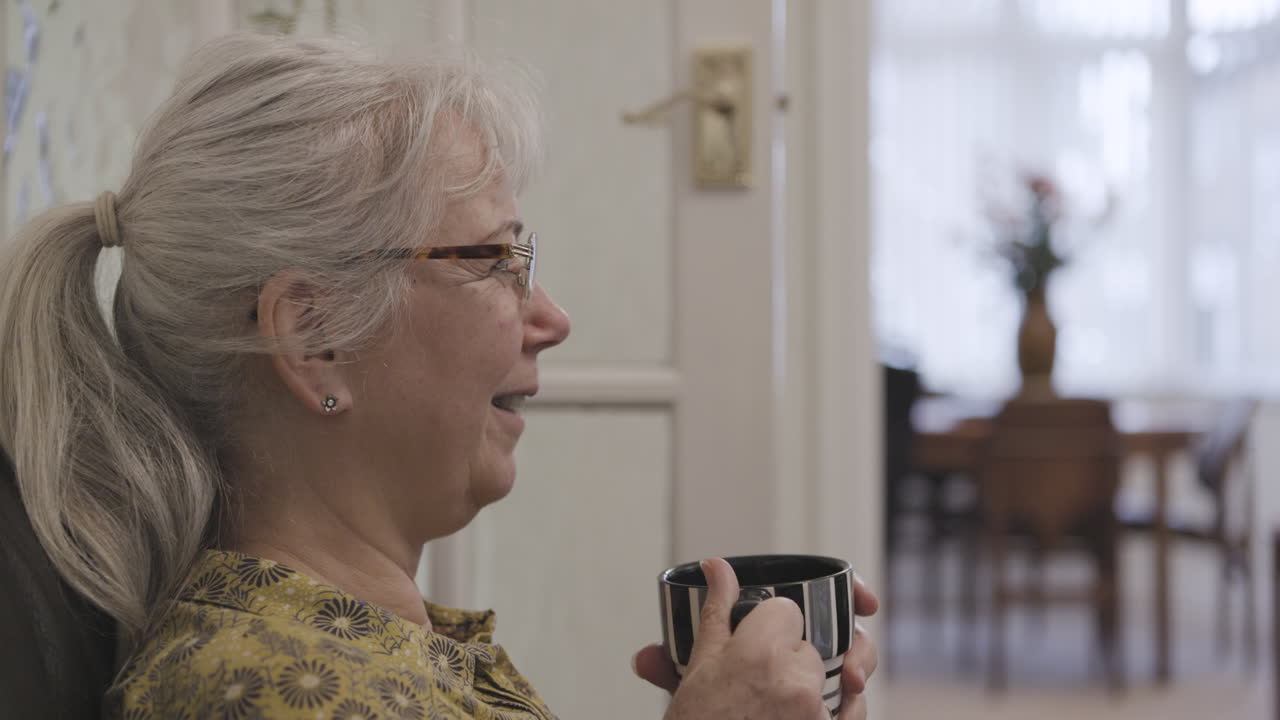 Ældre kvinde holder kaffekop