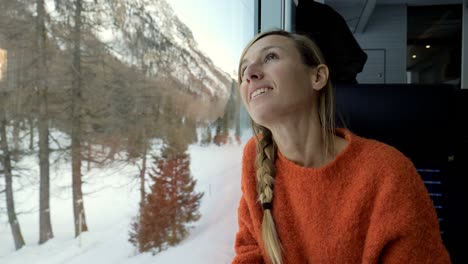 solo traveller woman tourist in train visiting switzerland enjoying beautiful panorama through window