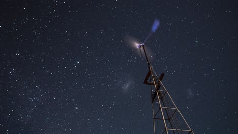 Lapso-De-Tiempo-De-Una-Pequeña-Turbina-Eólica-Con-Estrellas-En-Movimiento-En-El-Fondo