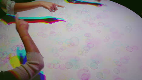manos coloridas haciendo estallar burbujas niños divirtiéndose jugando con luces multicolores niños jugando con colores del arco iris concepto de infancia feliz 4k