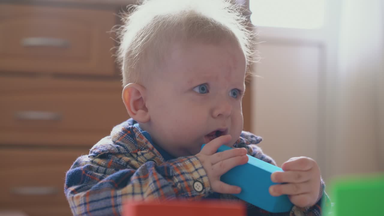 funny little boy upset of smashing cubes tower on soft bed