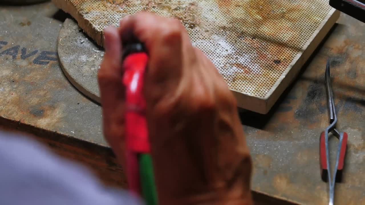 artesana elaborando un anillo con un soplete