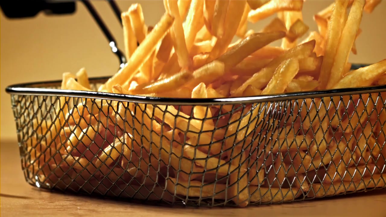 Batatas Fritas Douradas Caindo em uma Cesta de Metal