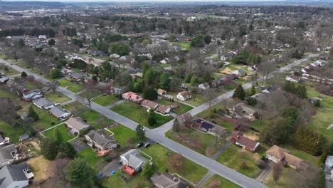 Aerial-birds-eye-flight-over-american-homes-and-buildings-with-green-grass-yards