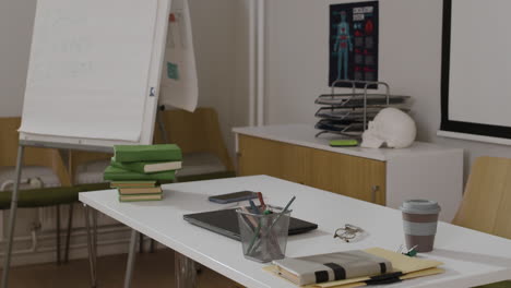 an office scene with desk, books, laptop, and skull