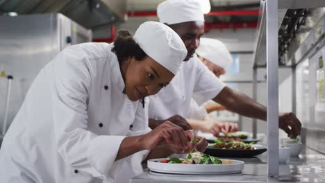 Grupo-Diverso-De-Chefs-Adornando-Platos-Y-Simulando-En-La-Cocina-Del-Restaurante