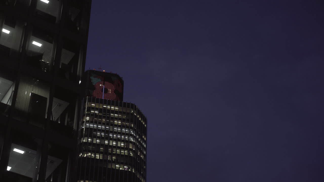 Reveal shot of the poppy symbol on a building during the night in London