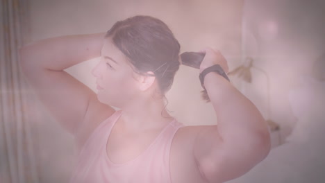 animation of flickering spots of light over woman tying her hair before exercising at home