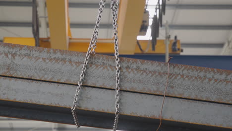 vigas metálicas transportadas por una grúa de pórtico en movimiento lento