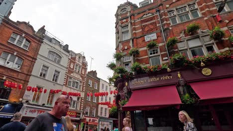 people walking past vibrant buildings and decorations