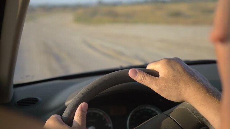 Uomo che guida un'auto in una serata estiva
