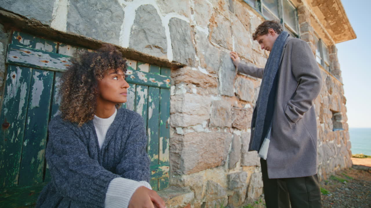 Frustrated pair feeling sad at chateau near ocean. Models posing abandoned place